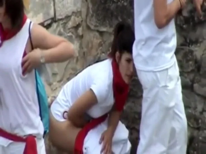 Uniformed girls pissing behind a car