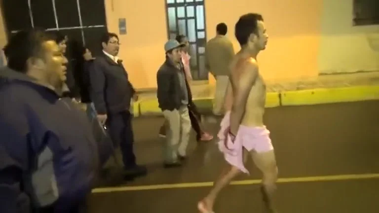 Cops walk a nearly naked criminal down the street