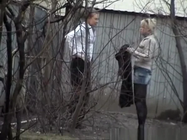 Girls pissing behind bush