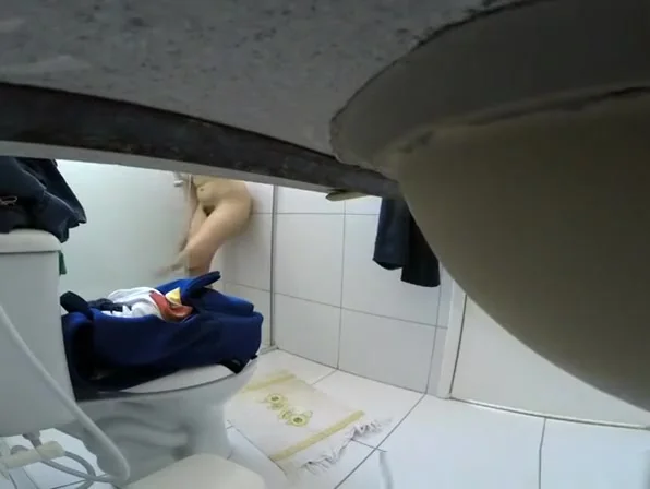 Woman takes off her clothes in bathroom