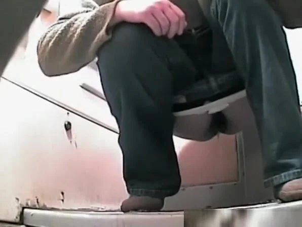 Woman in jeans peeing in toilet