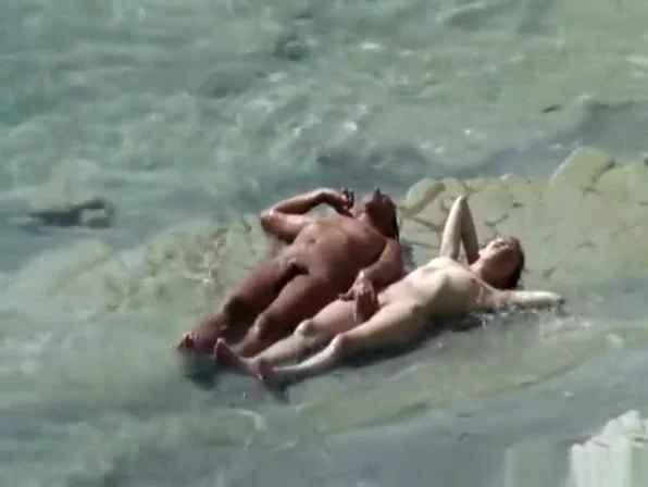 Nudist couple sunbathing and refreshing