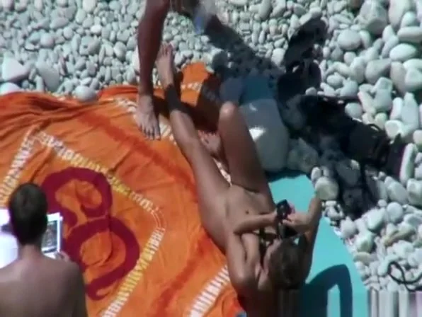Group of nudists sunbathing in the beach