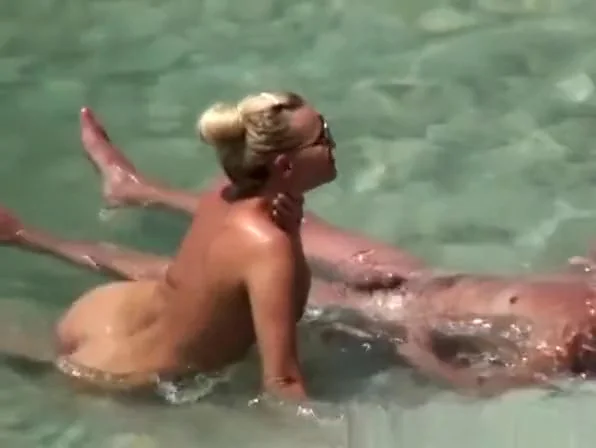 Nudist couple refreshing in the water