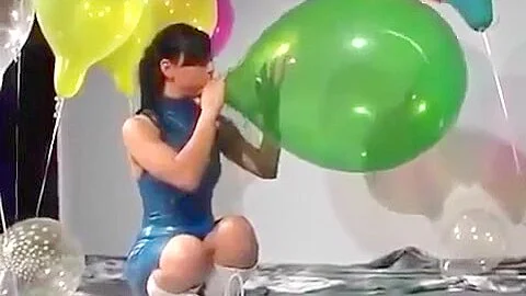 Sexy Girl In Latex Dress Blows to Pop Some Big Balloons