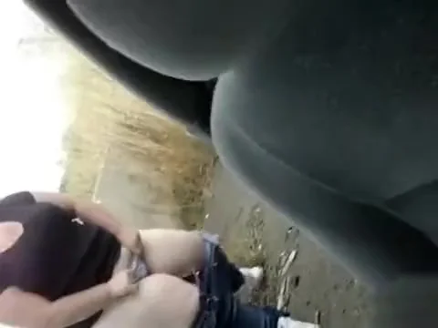 Chubby chick urinates on the ground outside the car