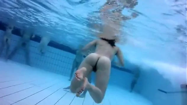 Naked men and women in the pool filmed underwater