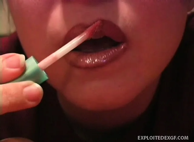 Naughty cutie puts some lip gloss on her sensual and thick lips