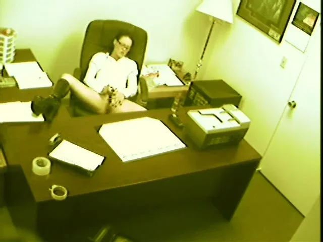 A security camera catches a lustful babe pleasing her hungry snatch in the office