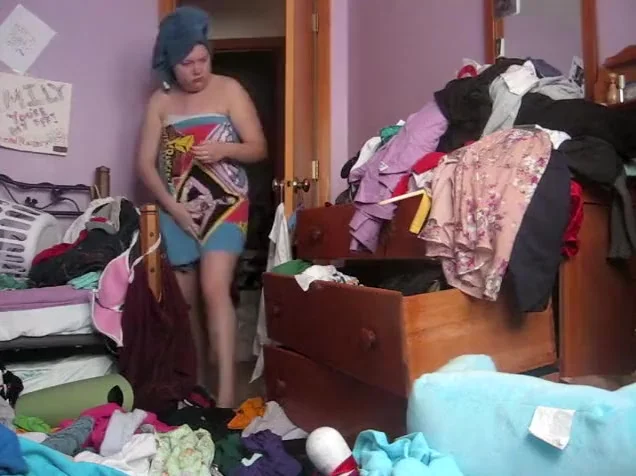 Chubby woman changes in a messy room