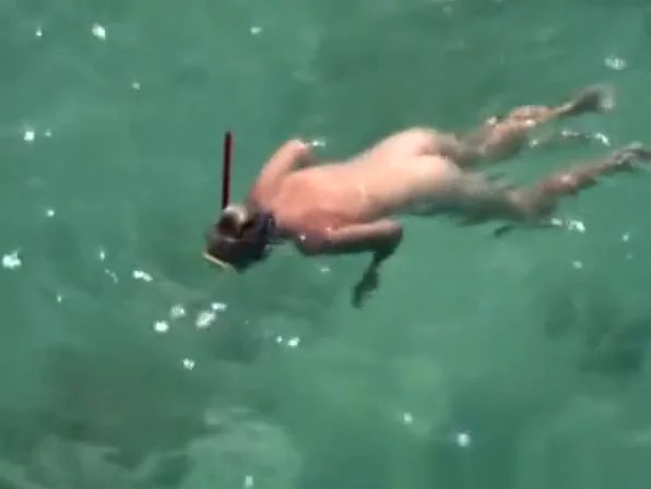 Nudist woman swimming in the water