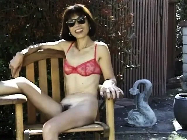 Sexy Asian mom drops her panties and teases with a glass dildo outside