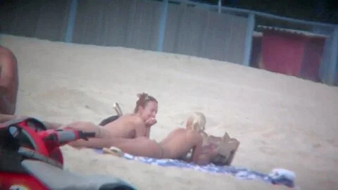 Beach spy captures two friends sunbathing topless