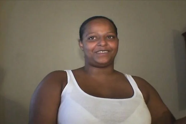 Dark skinned whore Cassy flashes her big tits and blows a white pole