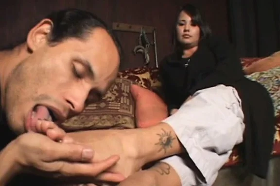 Beautiful dark-haired chick orders a guy to nuzzle on her feet