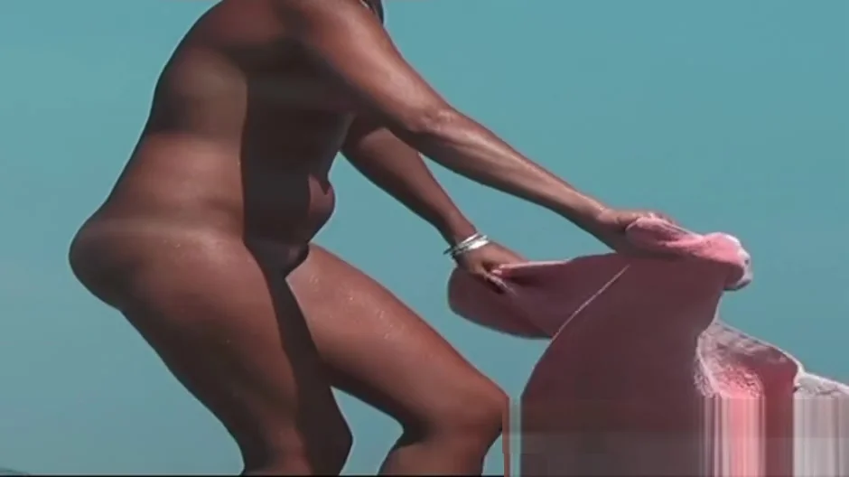 Sexy toned body walking naked on a crowded beach