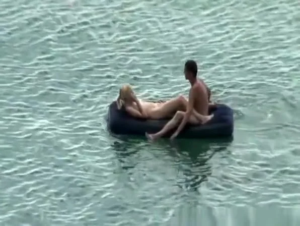 Group of nudist in air mattress in the water