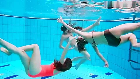 Three nude girls have fun underwater