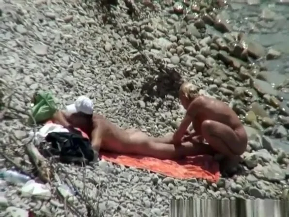 Blonde nudist woman enters the water