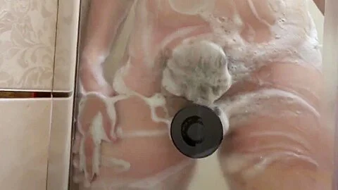 Pregnant milf in the lather in the shower masturbates with a dildo. Rubber dick fucks hairy pussy.